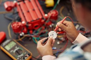 Close up of child building robot and wiring circuit board during engineering class at school, copy space